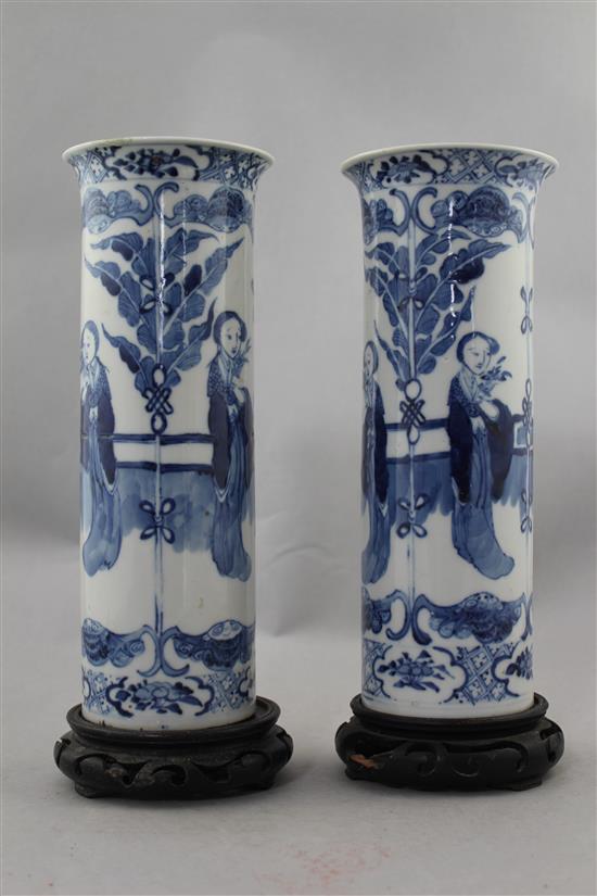 A pair of Chinese blue and white Long Eliza cylindrical vases, late 19th century, 26cm., ebonised wood stands